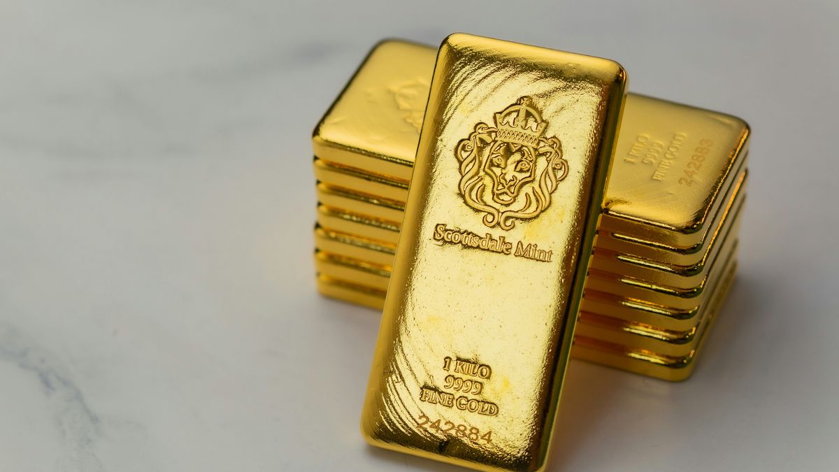 Stack of gold bars on white marble