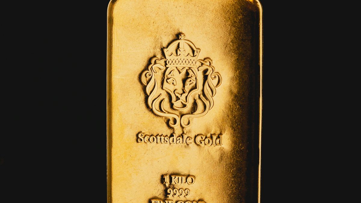 Single 1 kilo gold bar standing on a black background